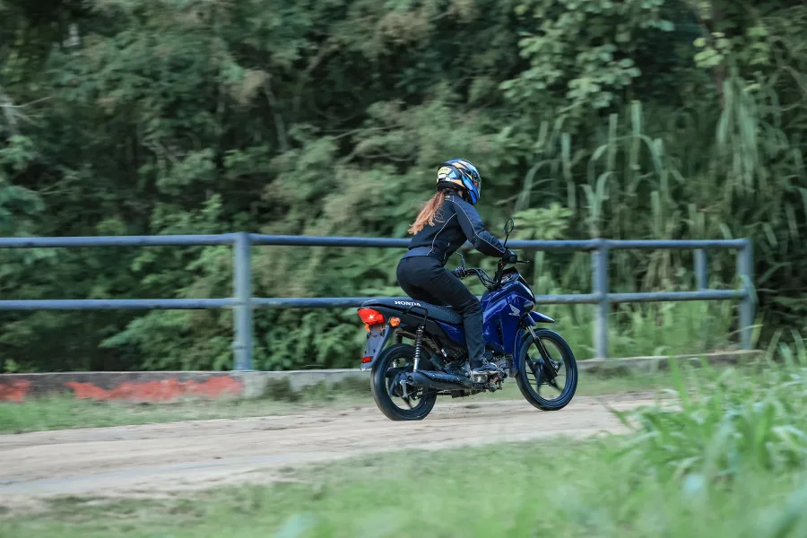 O visual mudou sem exagero. Continua básica, mas mais resistente. A carenagem protege melhor e aguenta uso duro, típico de quem depende da moto todos os dias